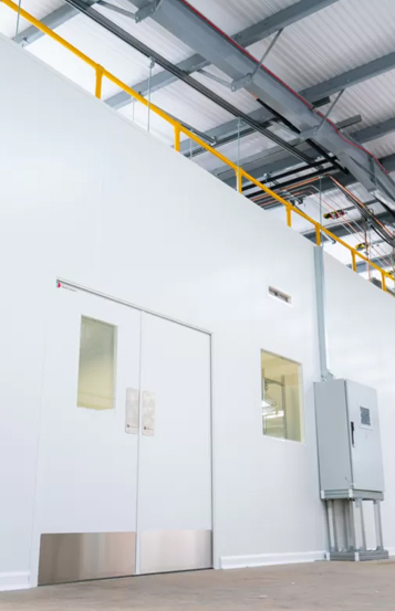 Interior of a modular cleanroom with wall panels, observation windows and overhead services ducting