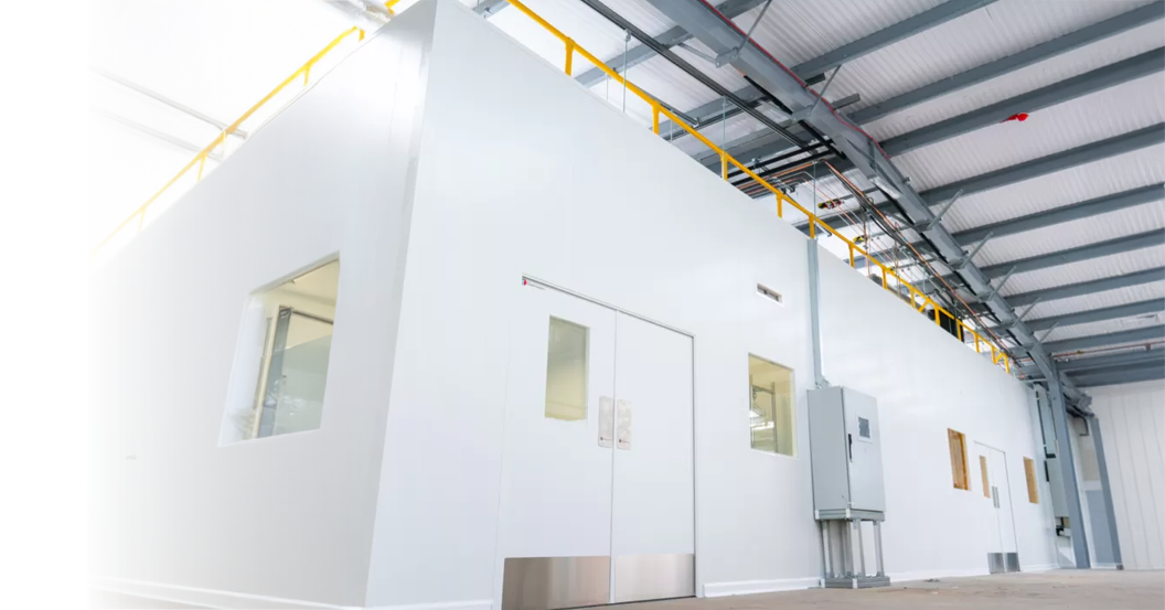 Interior of a modular cleanroom with wall panels, observation windows and overhead services ducting