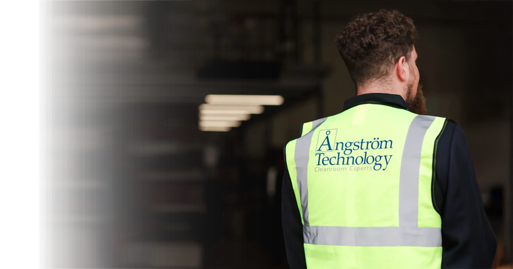 Angstrom Technology team member wearing branded safety vest on-site during cleanroom project delivery